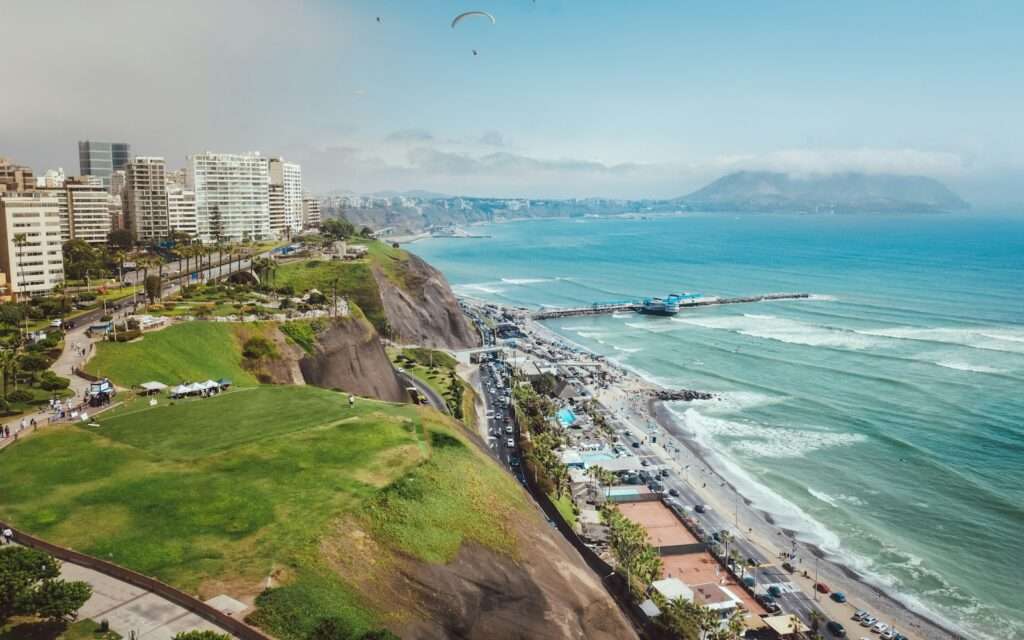The Miraflores cliffs and Costa Verde coastline in Lima with a paraglider overhead